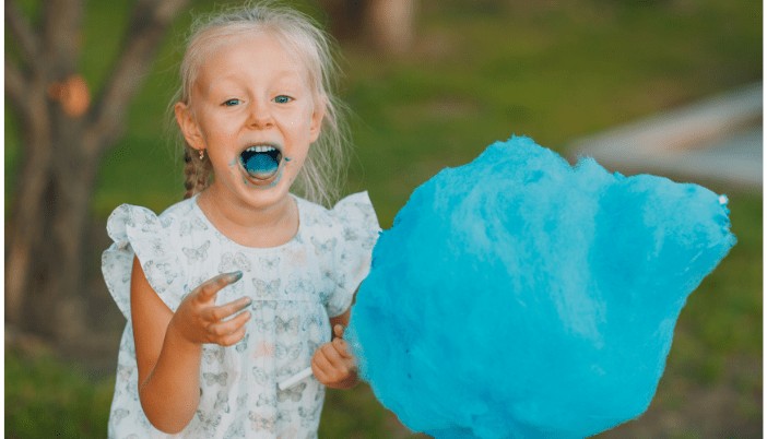 girl eating a blue cotton candy